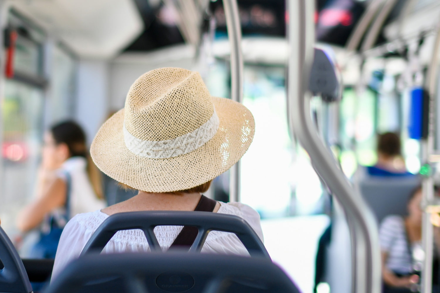 Riding the bus to summer events in Snohomish County A woman wearing a summer straw hat sits on the bus.