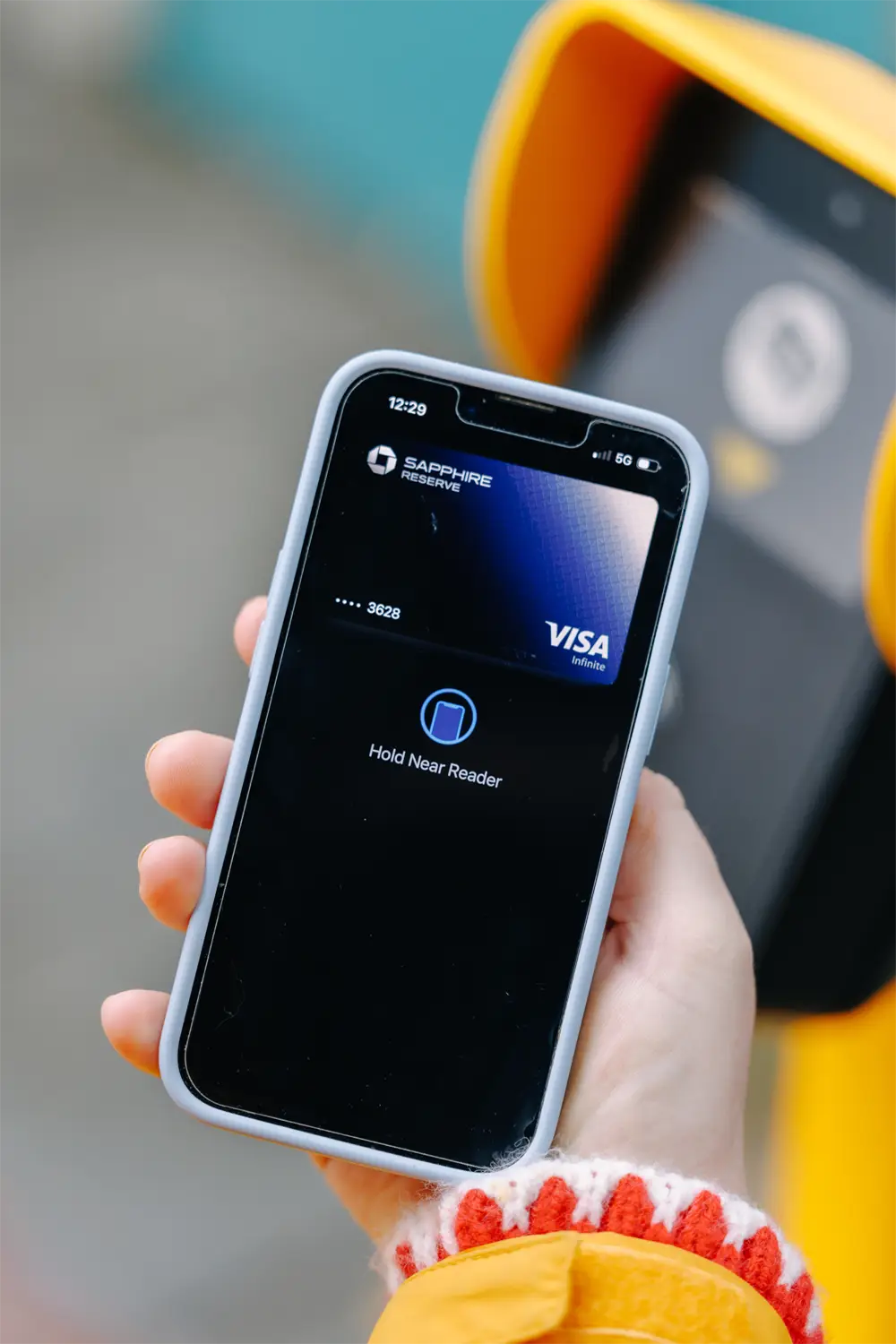 a rider paying their transit fare at an ORCA card reader using a credit card saved to their phone
