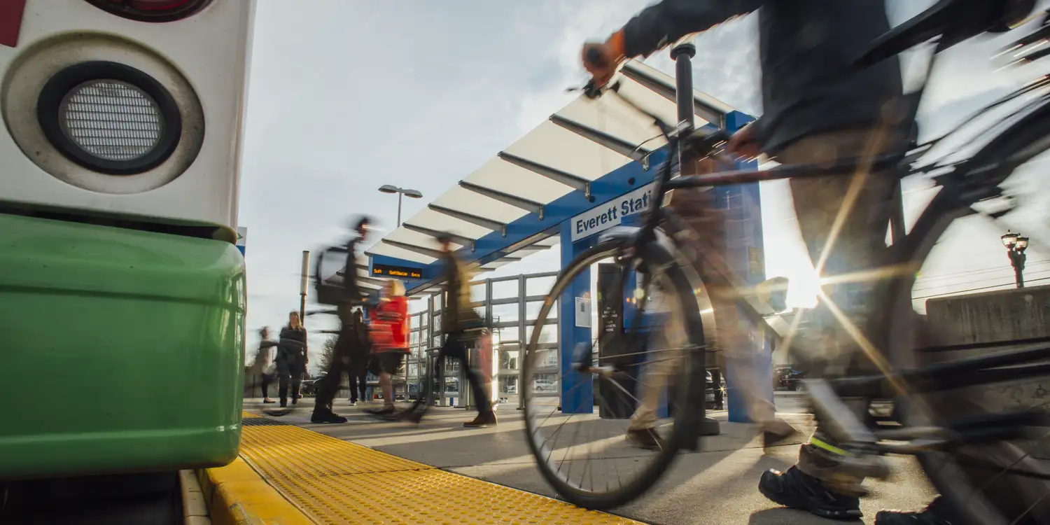 Transit Development Plan A person pushes a bike next to a bus stop at Everett Station.