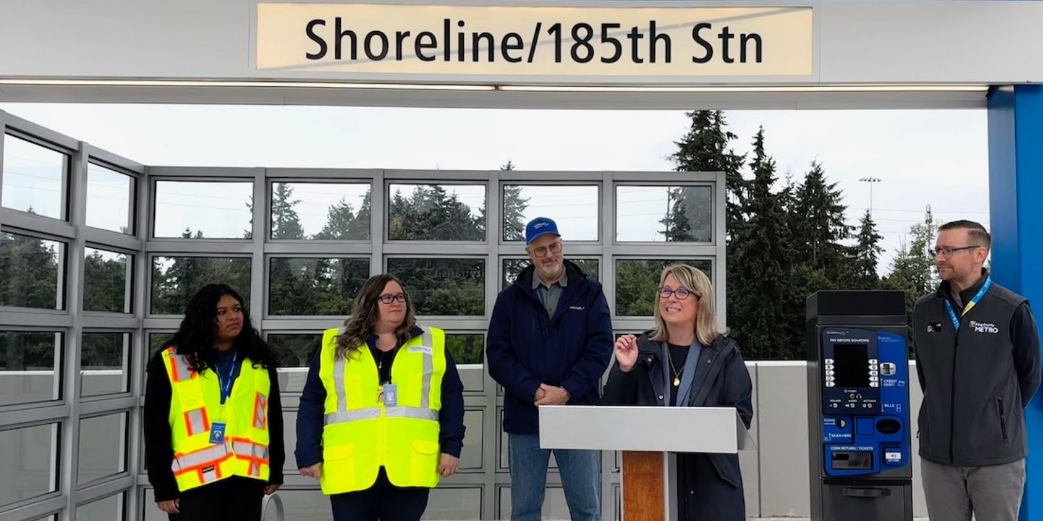 Community Transit CEO Ric Ilgenfritz and General Manager Michelle Allison of King County Metro stand in front of the Swift Blue Line Shoreline/185th St Station to speak to media.