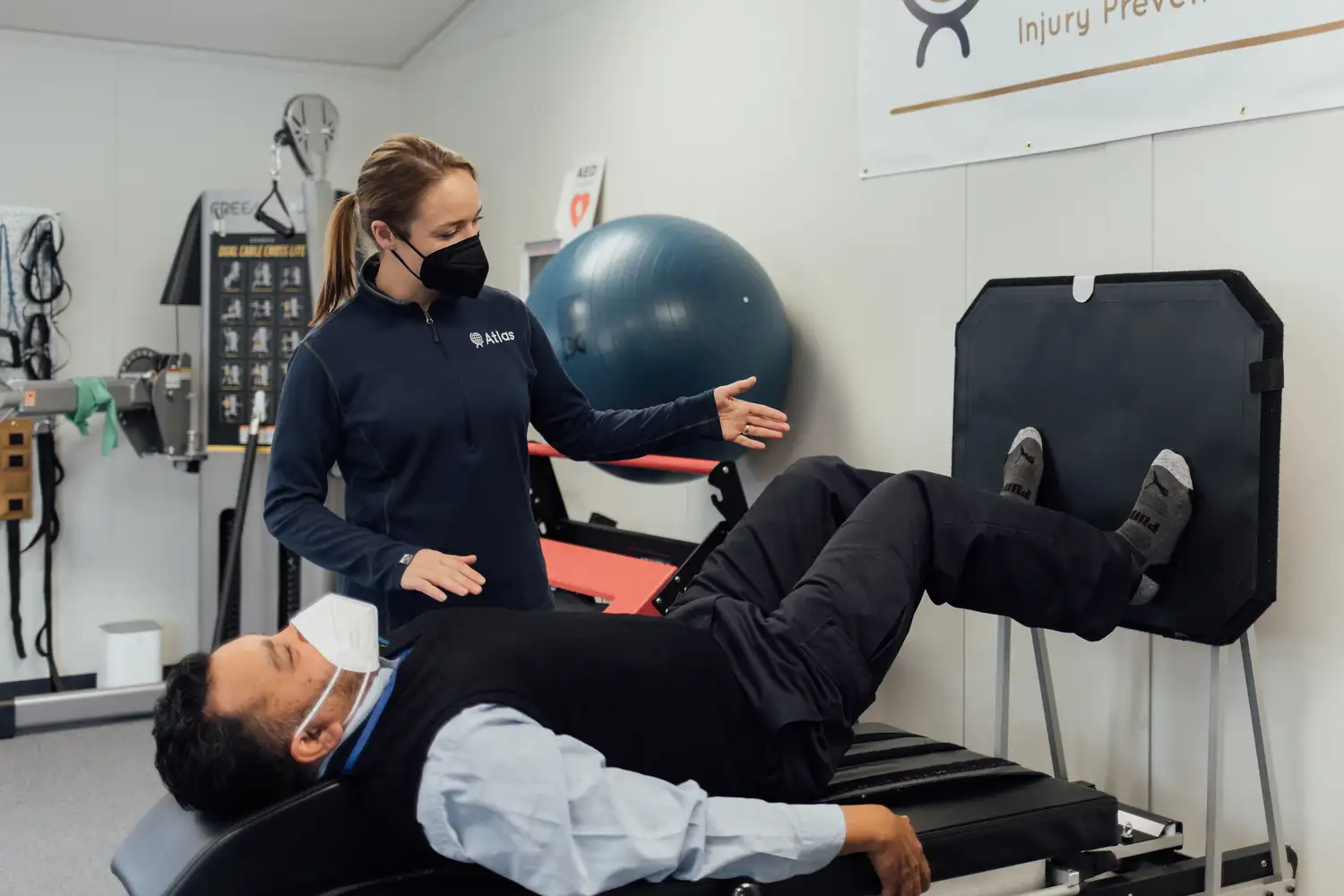 an Atlas wellness program staffer assisting a CT employee with exercises