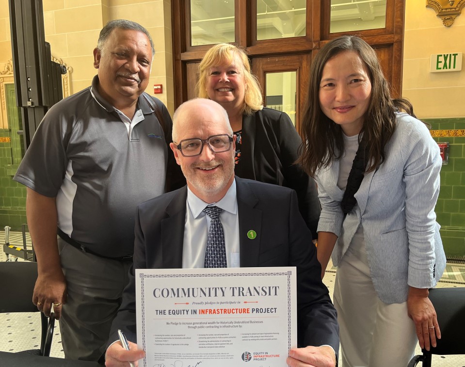 CEO Ric Ilgenfritz and other executive leadership holding an Equity in Infrastructure Project pledge certificate