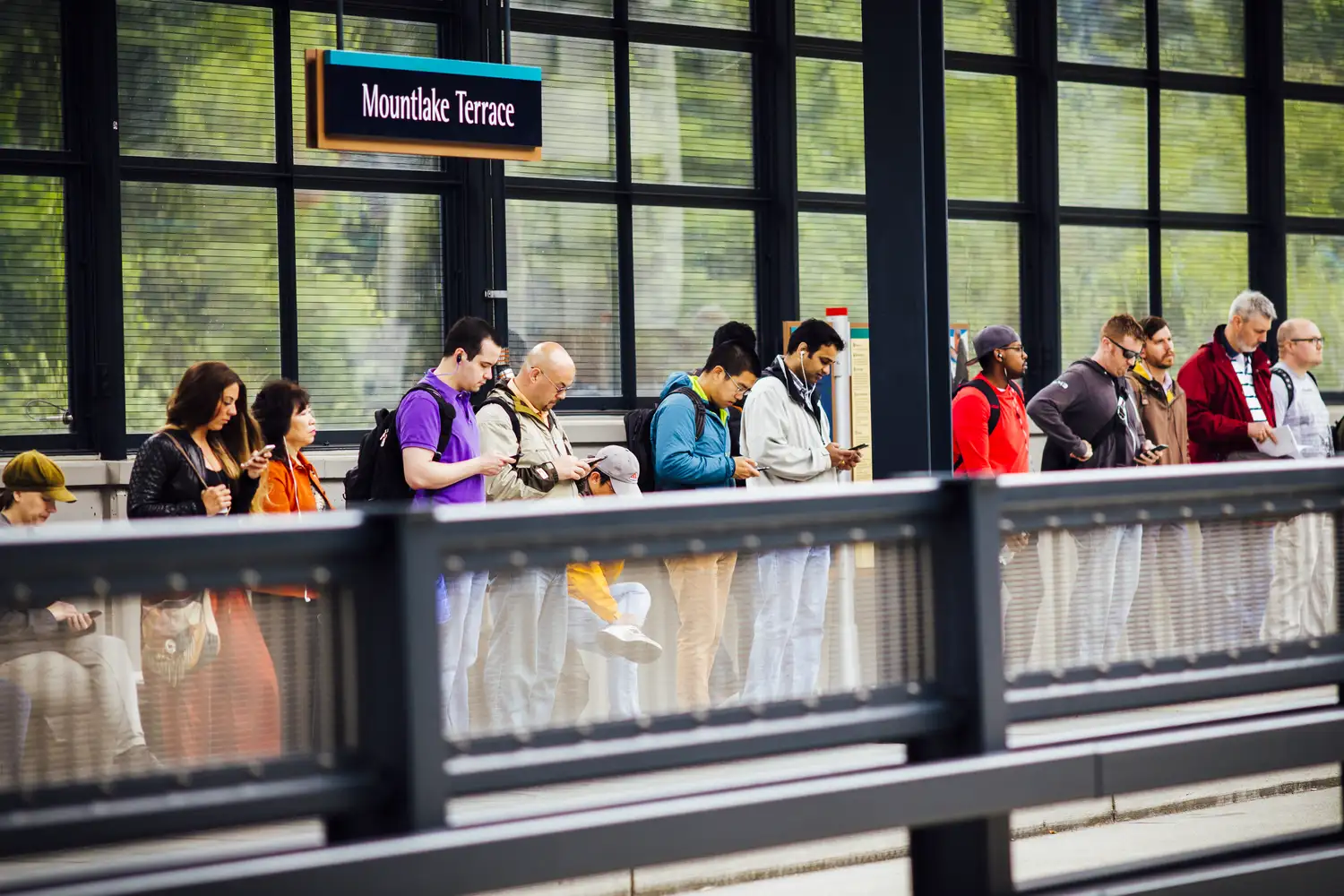 a group of transit riders waiting on a station platform