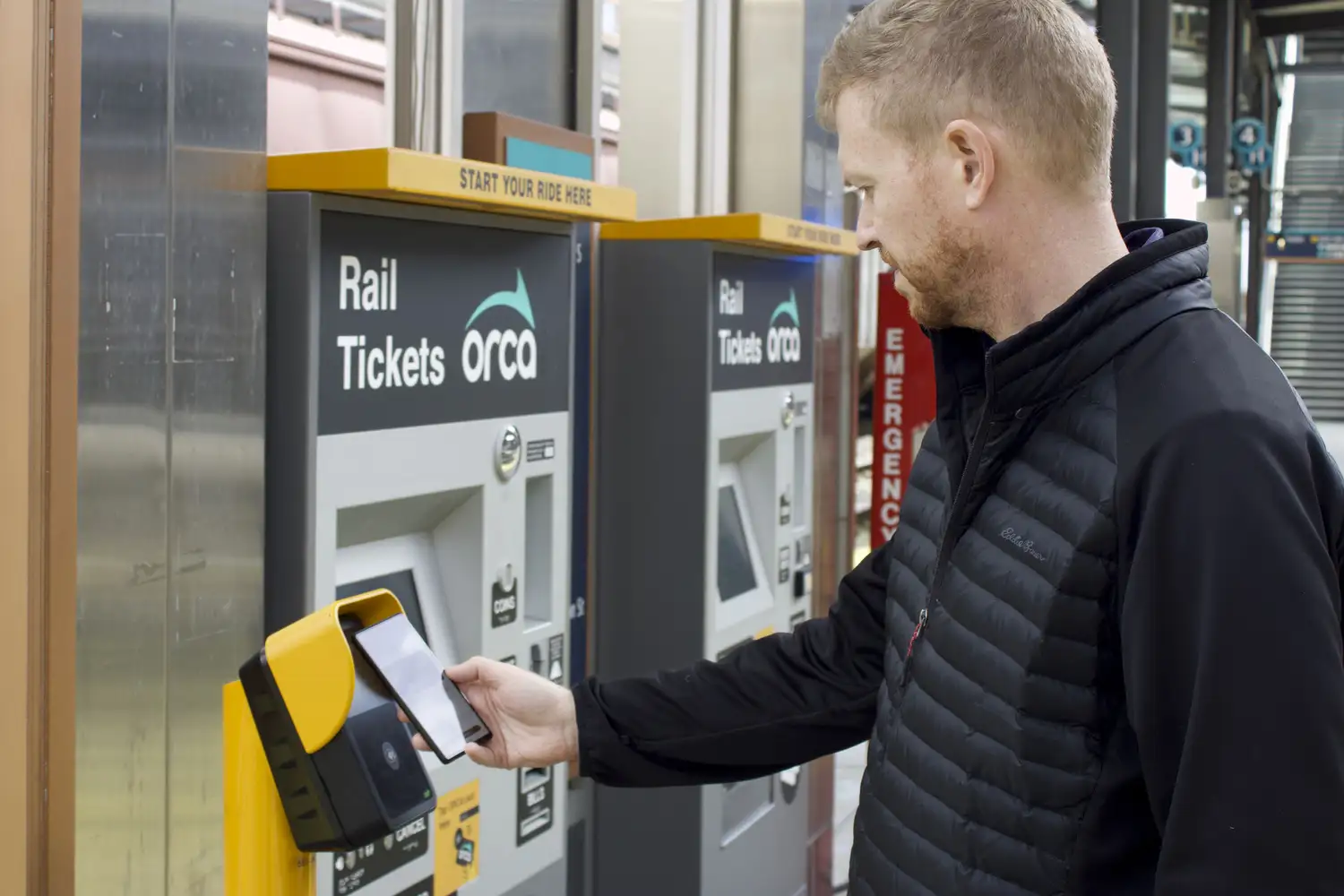 a rider using a virtual ORCA card with an Android phone at a scanner