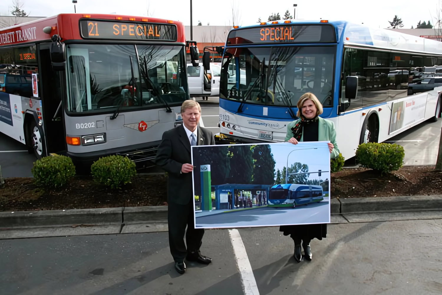 Everett Mayor Ray Stephanson and Community Transit CEO Joyce Eleanor pose with a picture of a Swift station and bus rendering in 2007