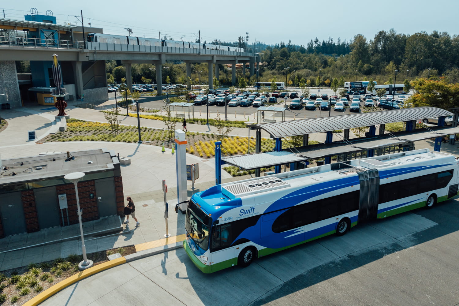 Lynnwood City Center with Community Transit Swift bus, Link Light Rail and a full parking lot in the background