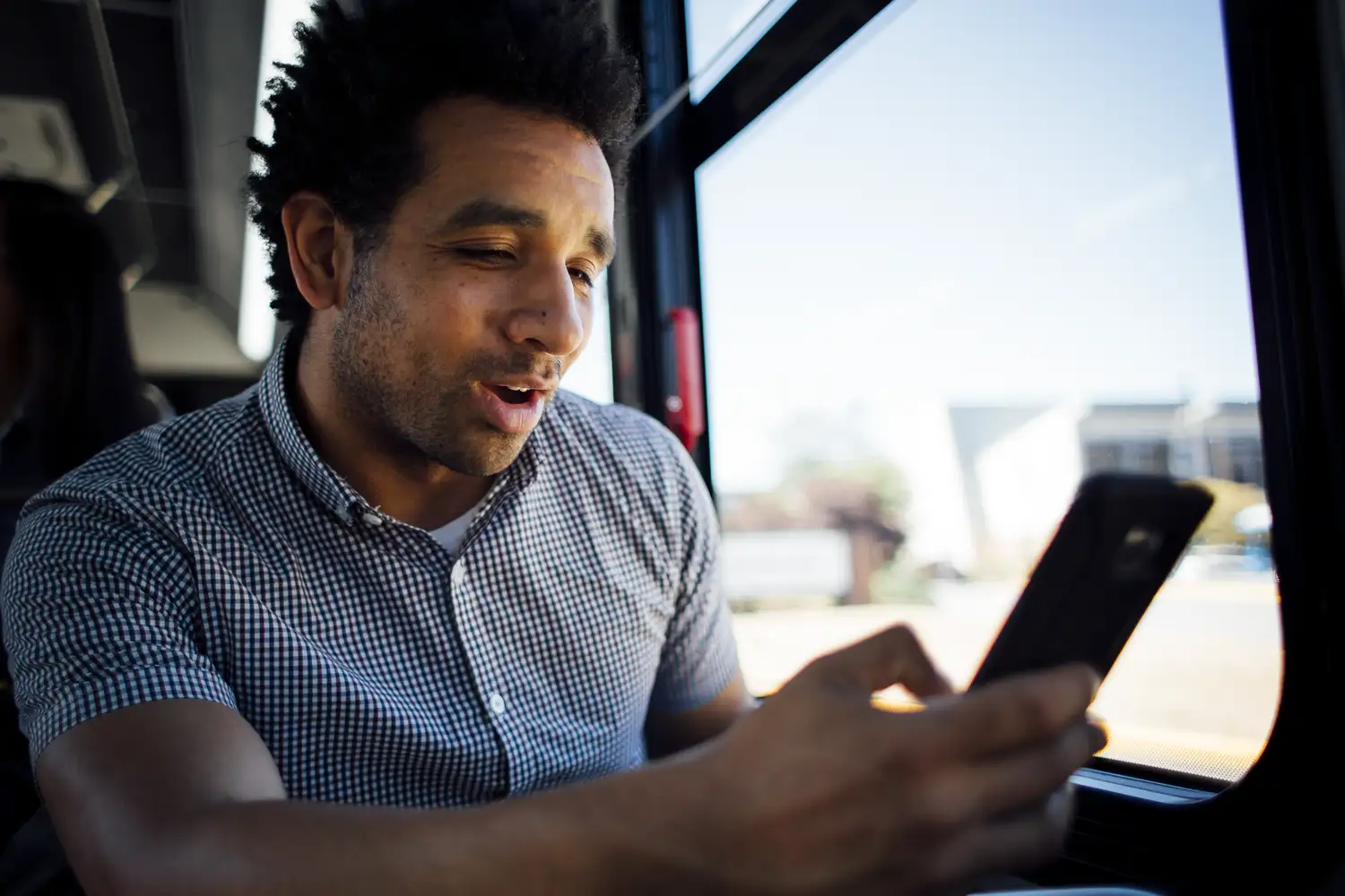 a transit rider on the bus checking their phone