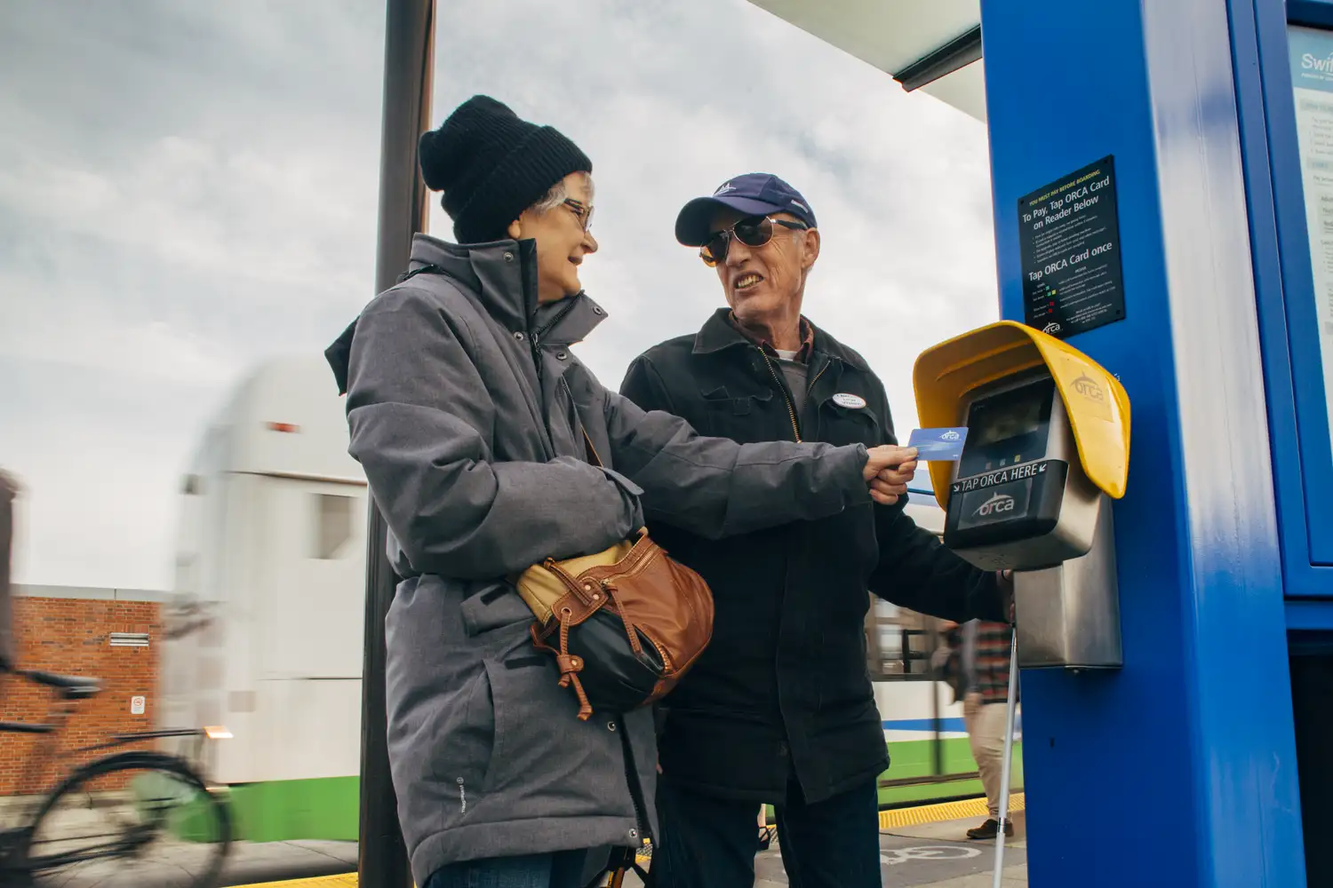 two older adult riders at a Swift bus station