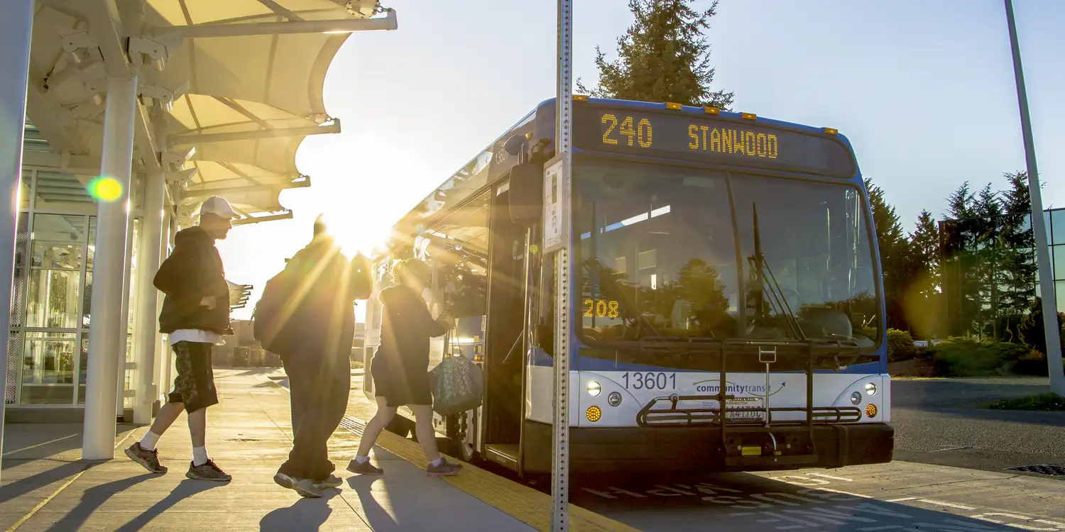 People getting on to a double decker Community Transit bus