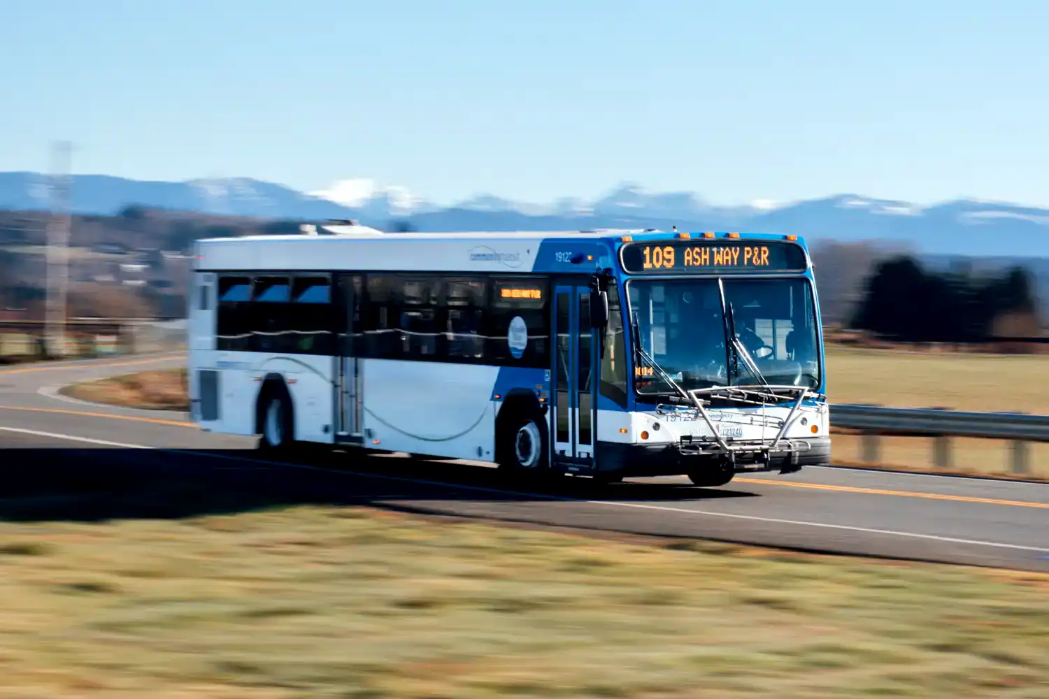 local routes a local service bus driving on a road through a field