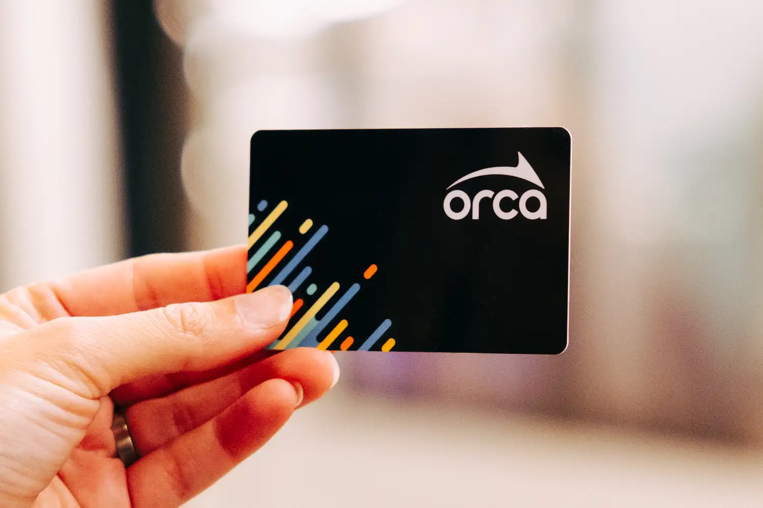 Close-up of a hand holding an ORCA card