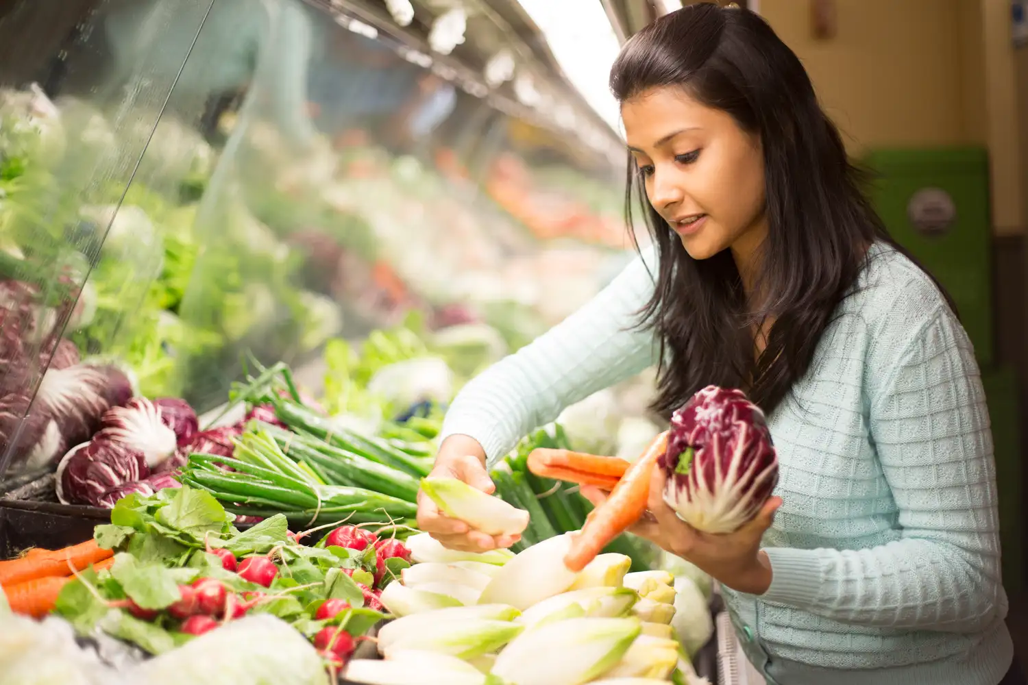 a woman shopping for produce in a grocery store